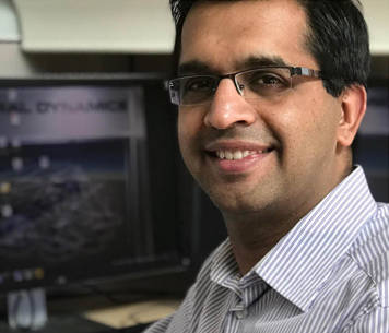 man smiling in front of computer